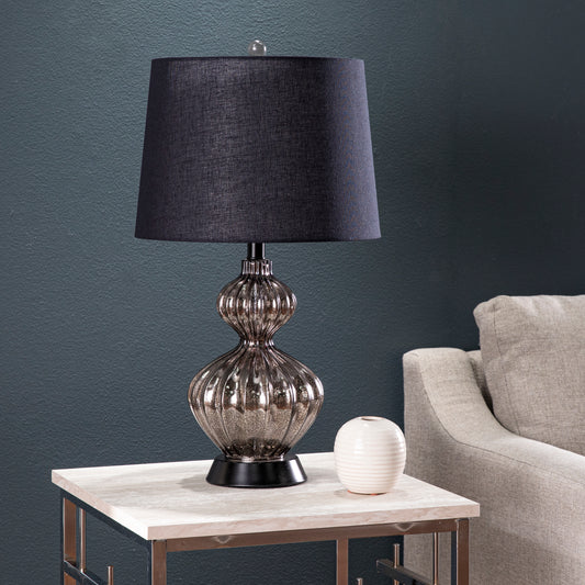 Textured black linen drum shade on a ribbed mercury glass table lamp with a black base