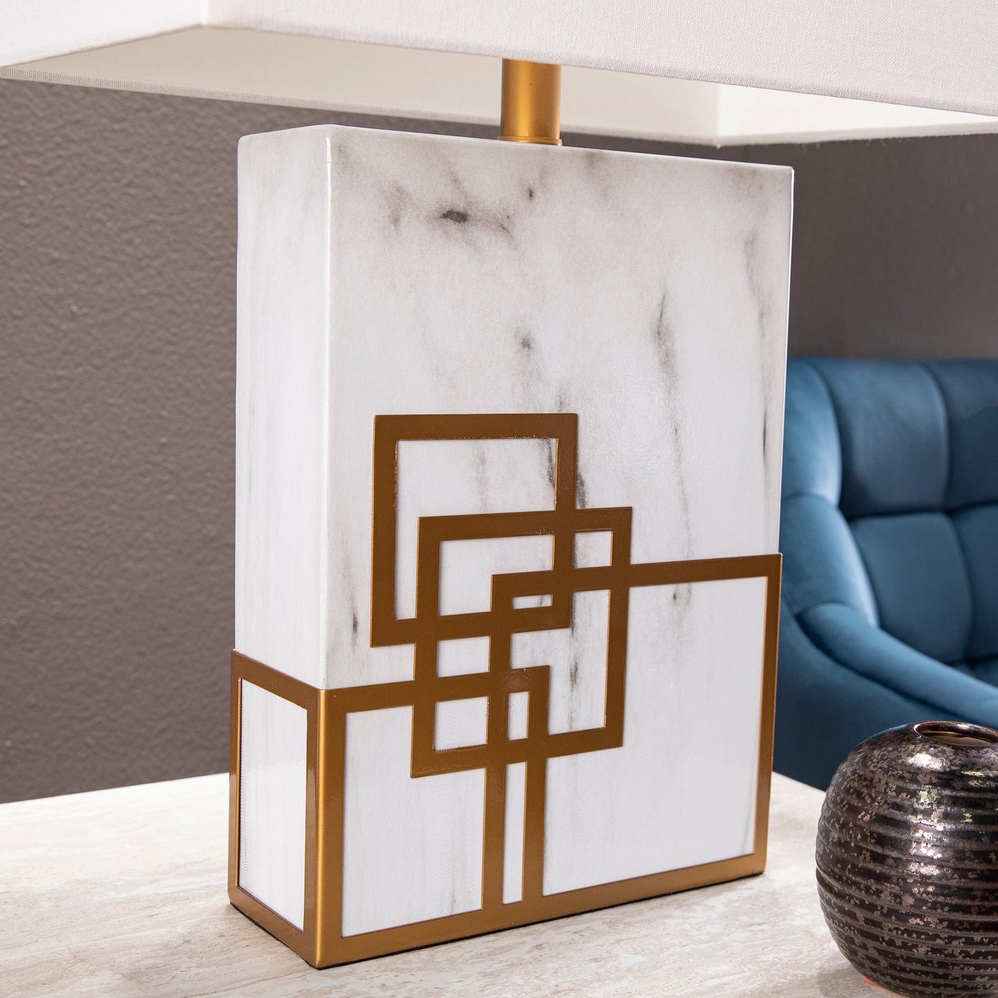 Rectangular white marble table lamp with gold geometric accents and a white linen shade