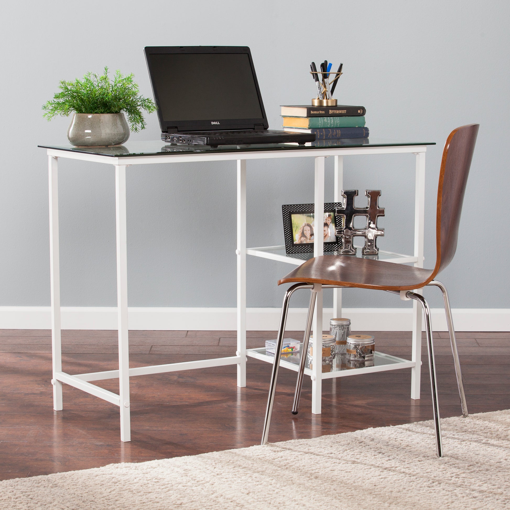 Sleek white metal desk with glass top and integrated shelf ideal for home office