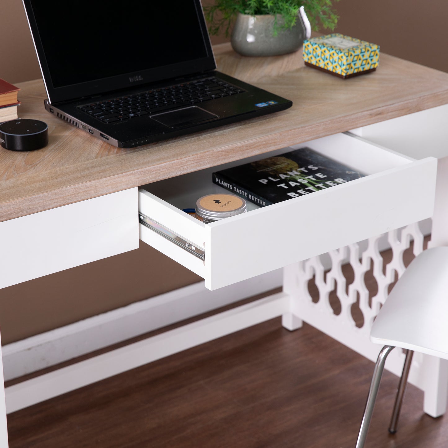 Black Dell laptop open on a modern white desk with a light wood surface