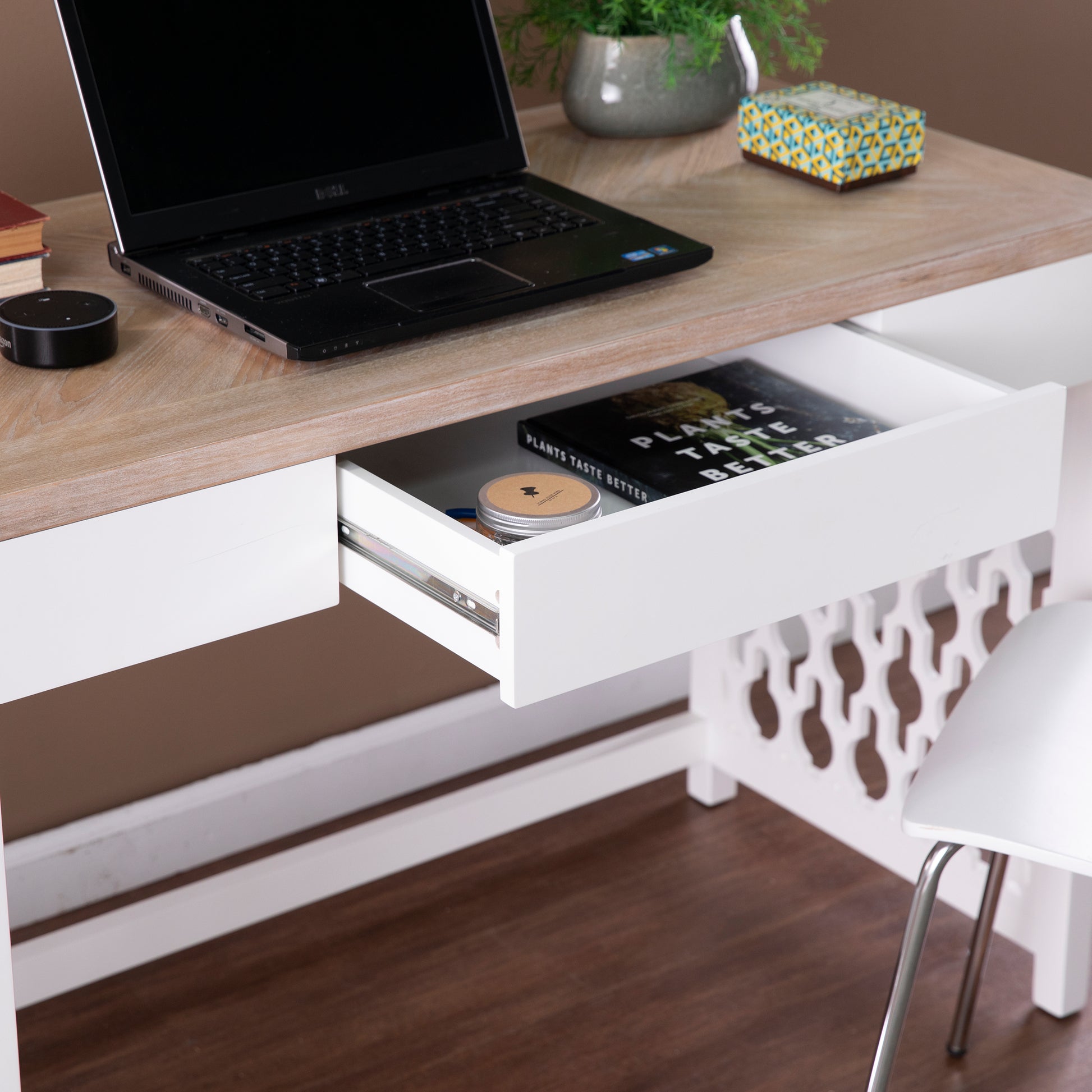 Black Dell laptop open on a modern white desk with a light wood surface