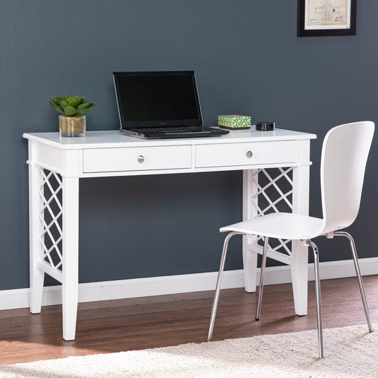 White wooden desk with lattice sides two drawers and a laptop for home office setup
