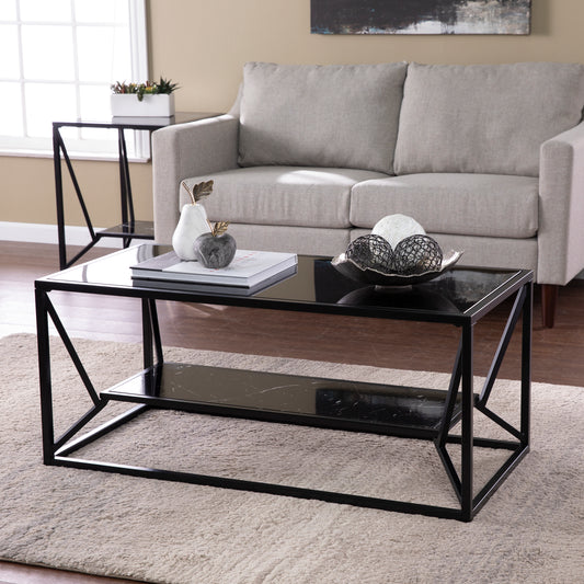 Modern black metal coffee table with glass top and marble shelf perfect for living rooms