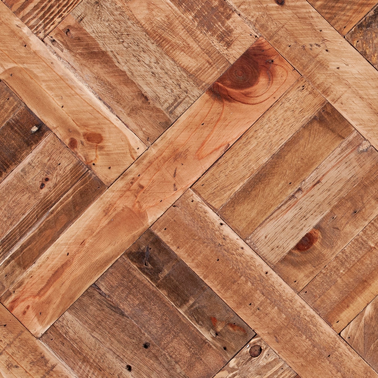 Rustic reclaimed wood planks arranged in a herringbone pattern with knots and nail holes