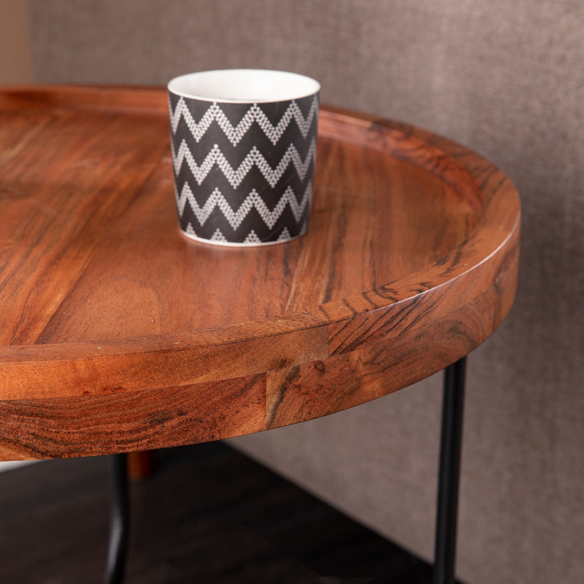 Round wooden tray with black chevron ceramic mug on top natural wood grain detail