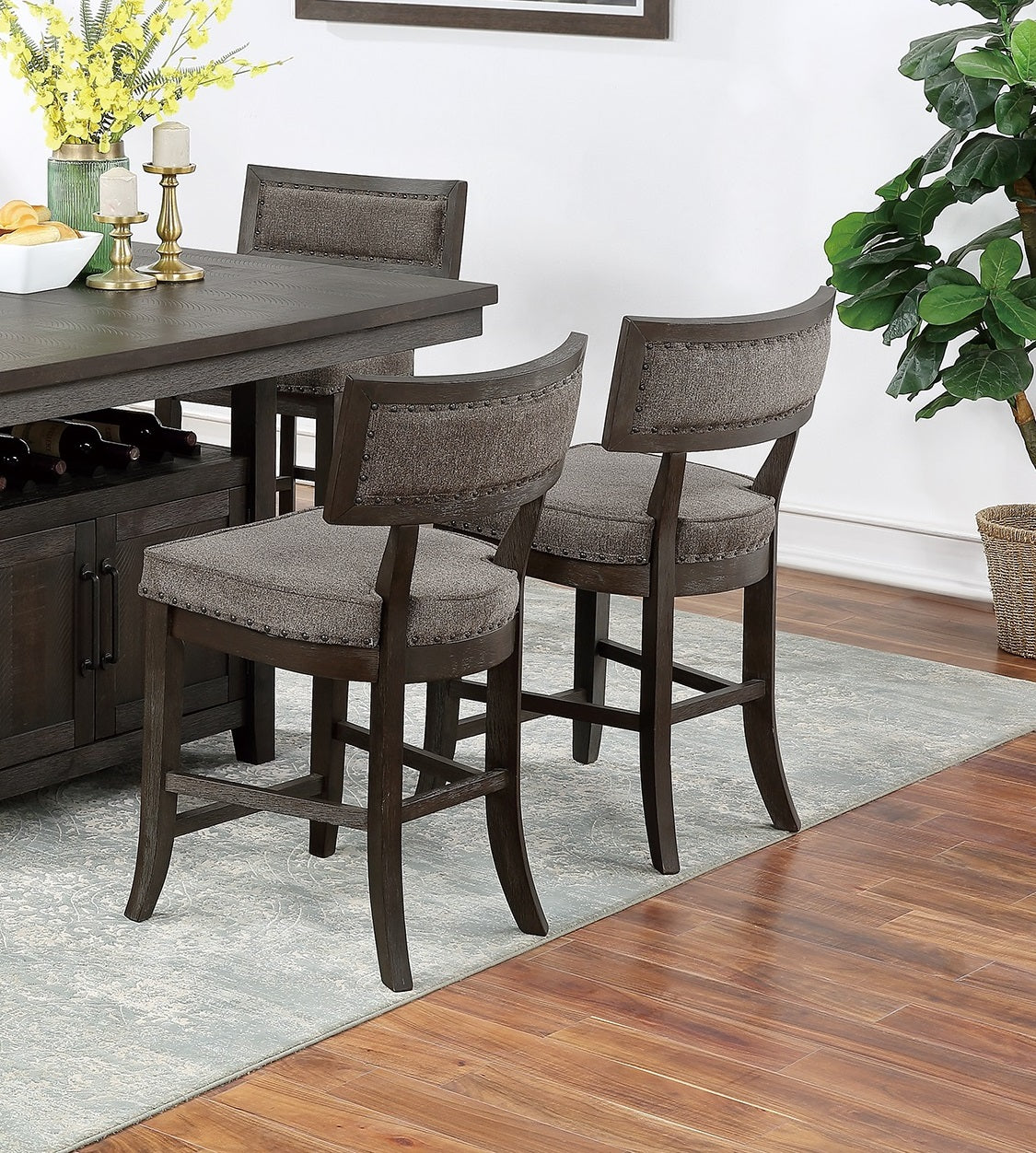 Padded grey upholstered bar stool with dark wood frame and nailhead trim