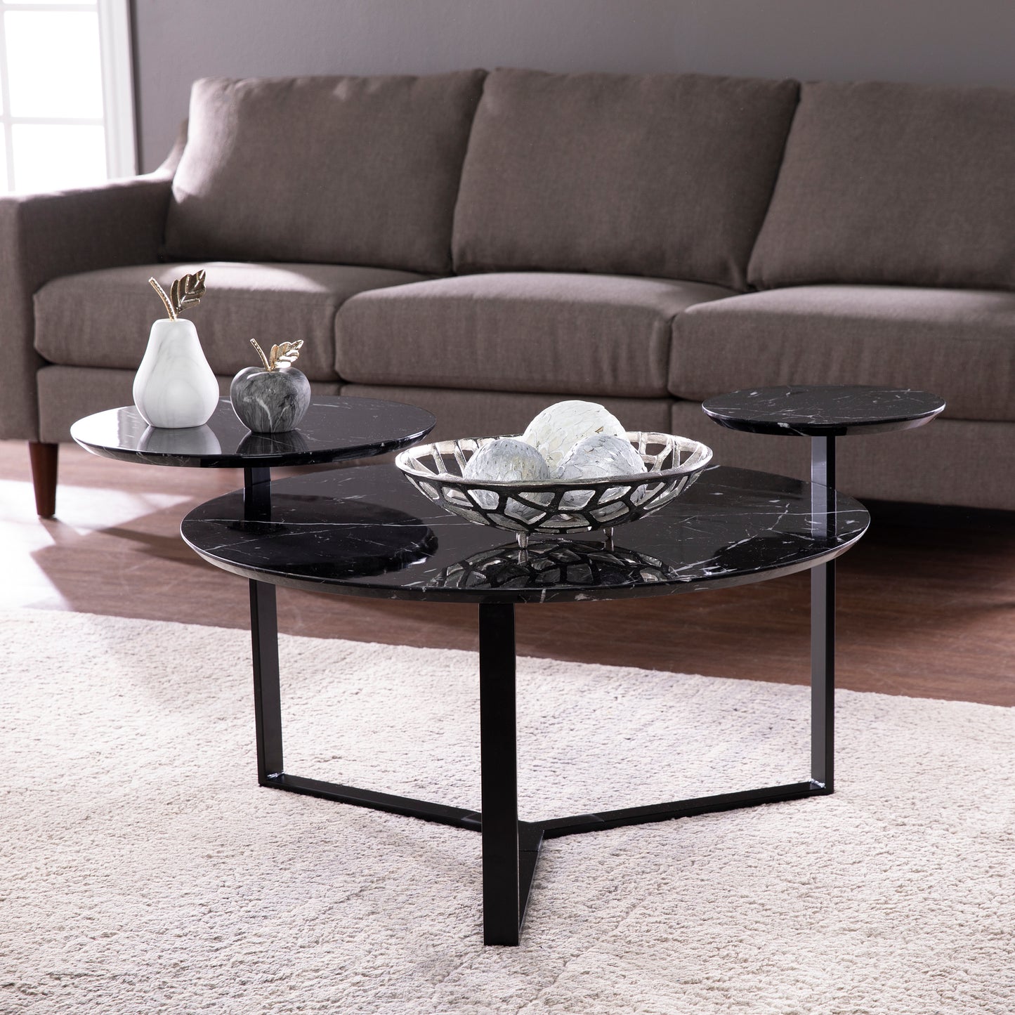 Modern tiered coffee table with black marble tops and metal legs