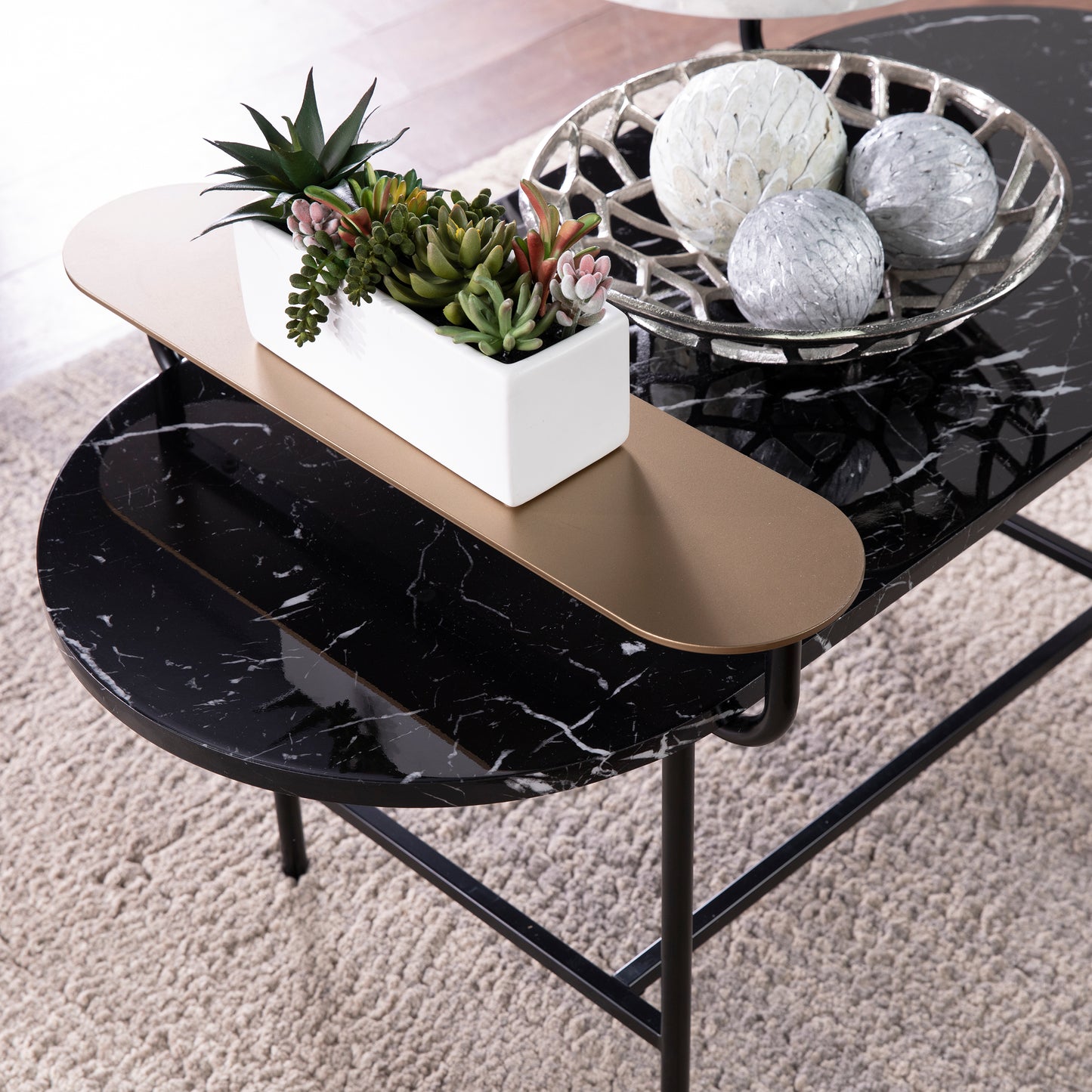 Black marble coffee table with cascading levels and modern brass accents