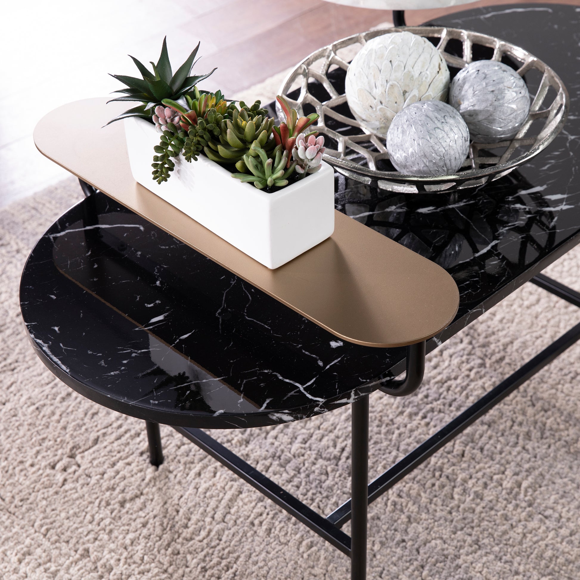 Black marble coffee table with cascading levels and modern brass accents