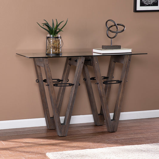 Rustic wooden console table with glass top featuring geometric legs and metal accents for entryways