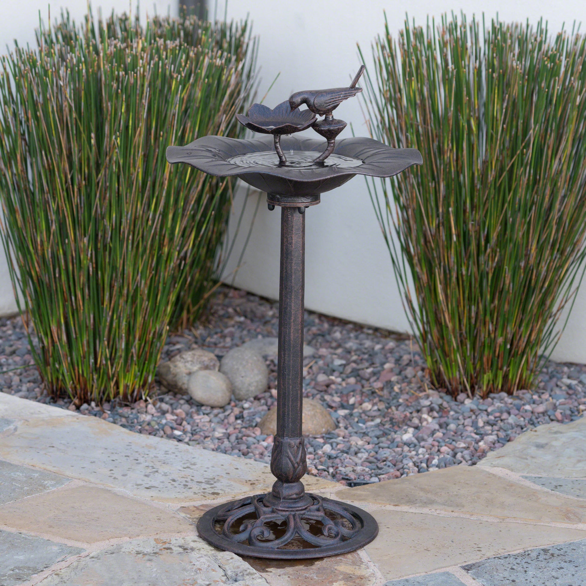 Rustic bronze bird bath with a decorative bird and floral accents perfect for garden decor