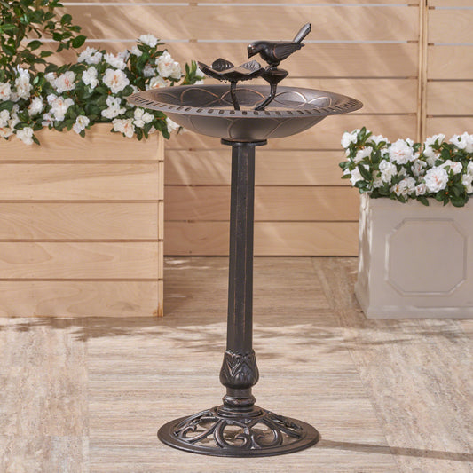 Antique bronze bird bath with ornate base and perched bird detail
