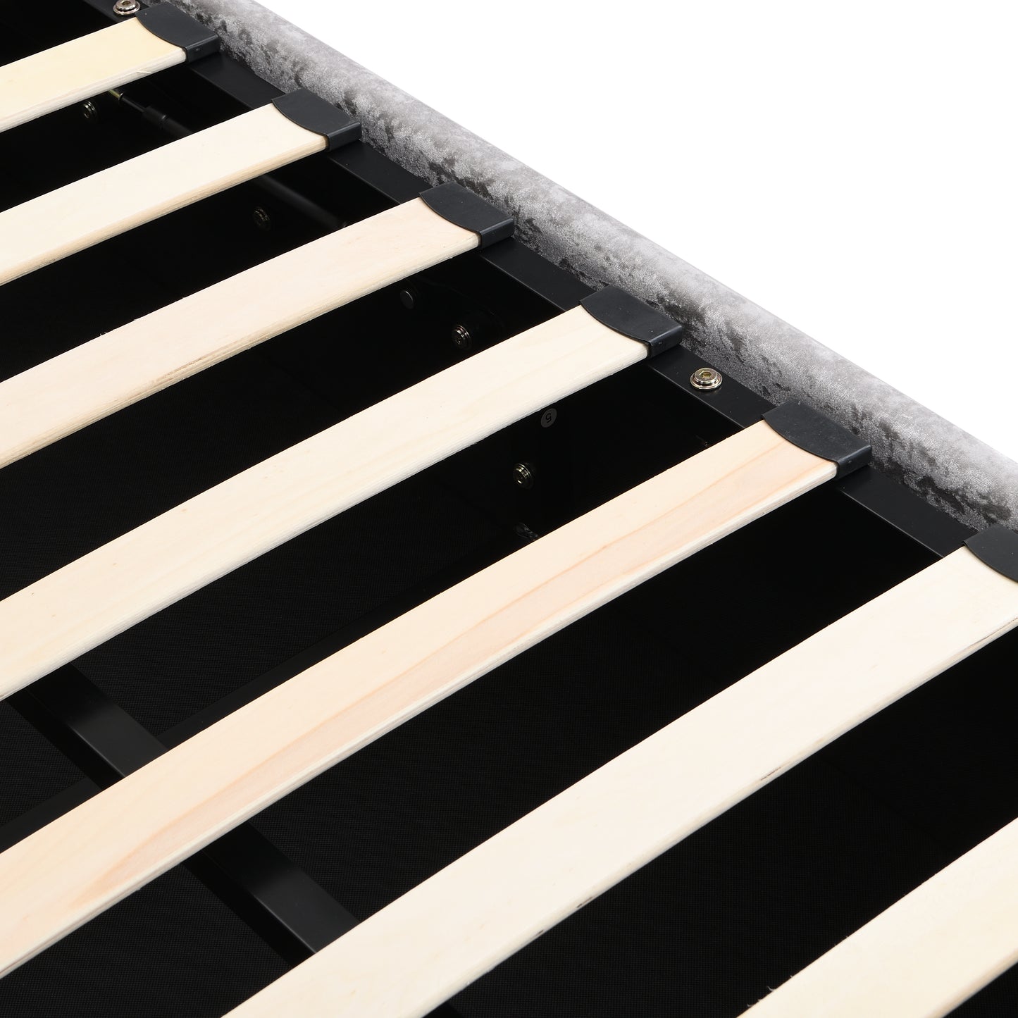Closeup of a grey velvet upholstered bed frame with wooden slats