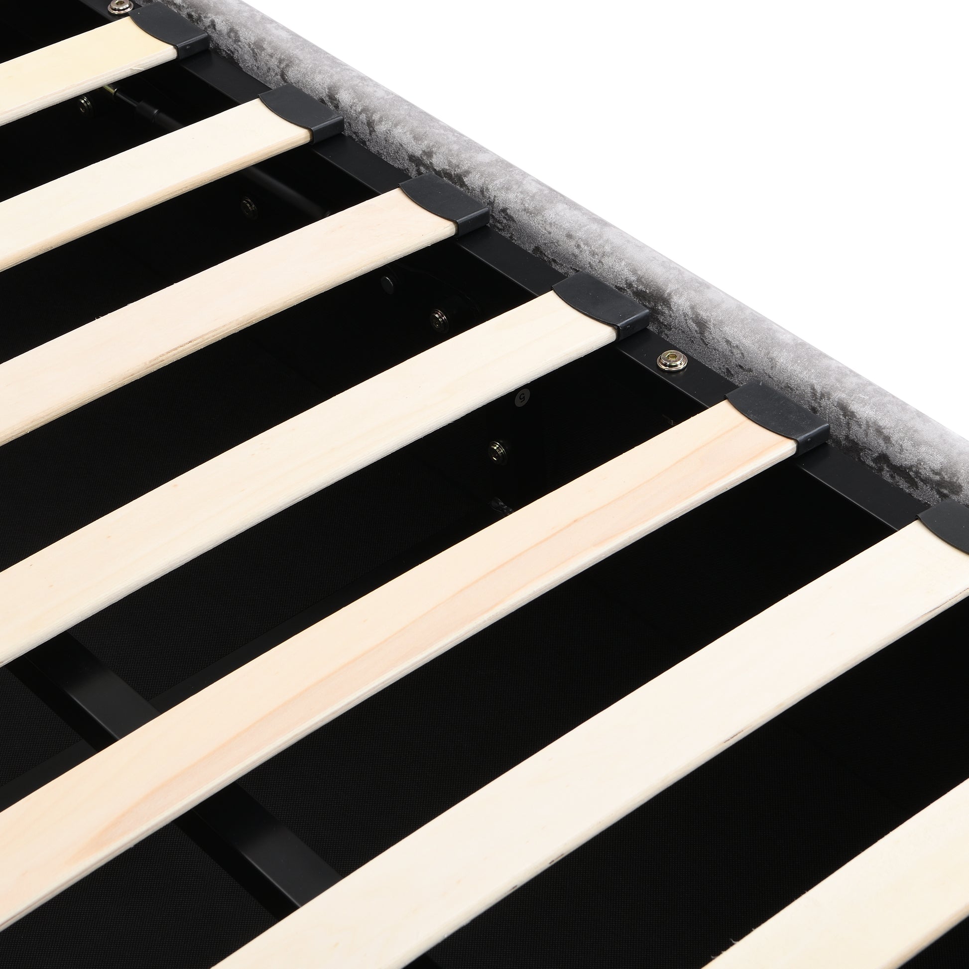 Closeup of a grey velvet upholstered bed frame with wooden slats
