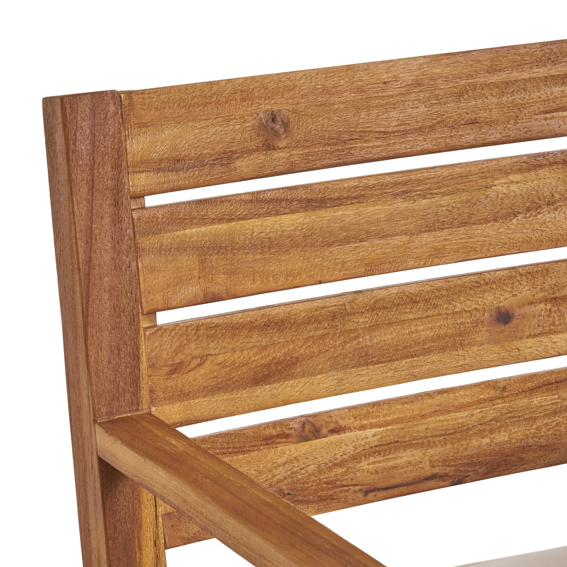 Closeup of warm brown acacia wood slats forming a modern outdoor chair back and armrest