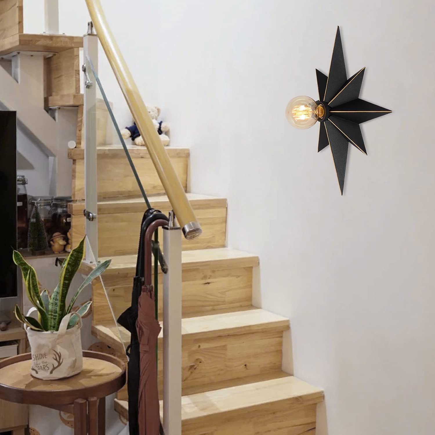 Black starburst wall sconce with exposed filament bulb for modern decor