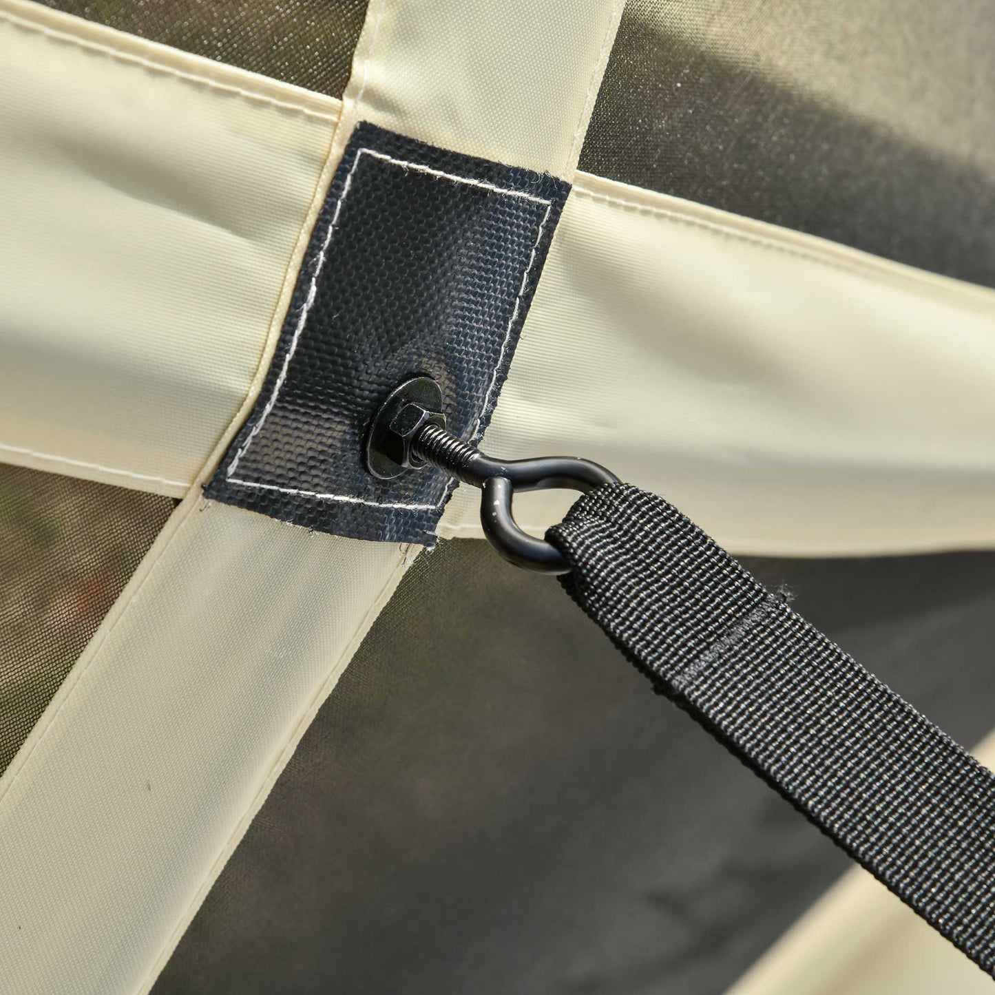 Closeup of beige fabric strap with metal grommet detail on a camping tent