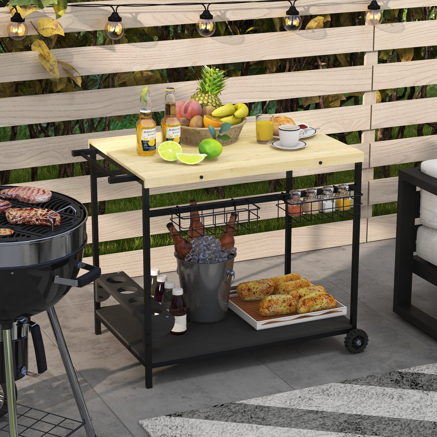 Black metal barbecue cart with wooden top filled with drinks fruits and bread ready for outdoor parties