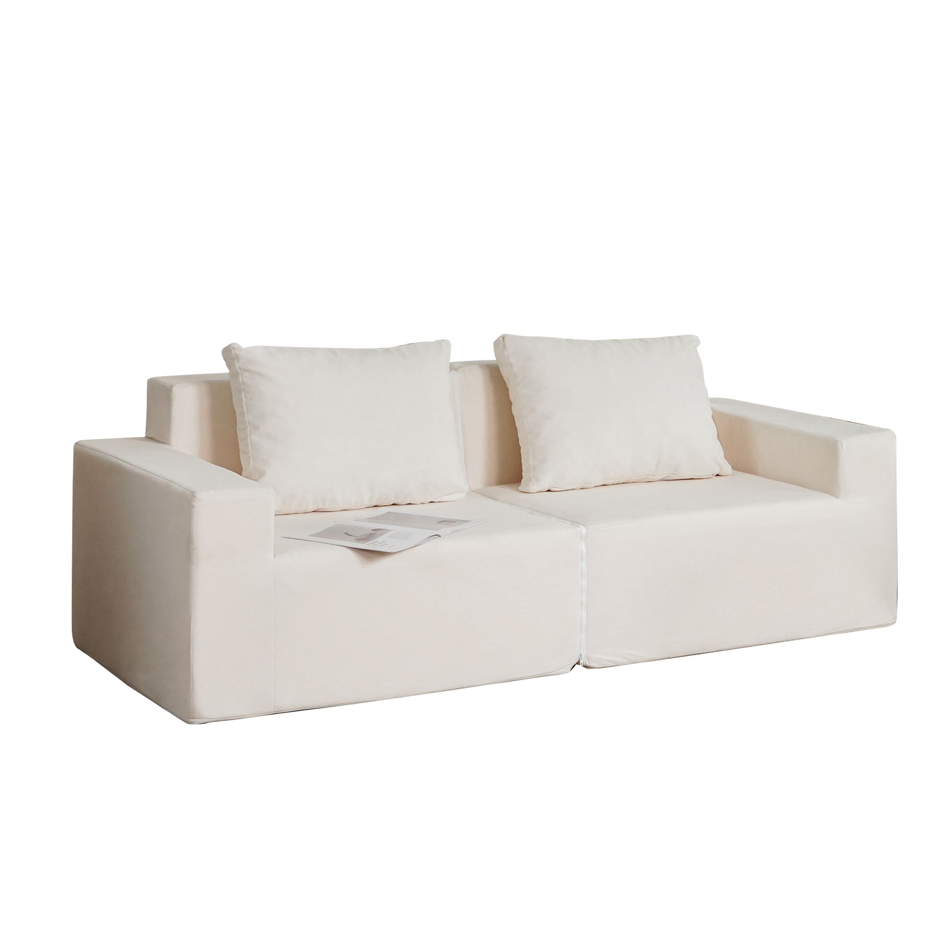Cream linen modular sofa with two throw pillows and open magazine