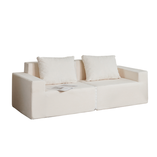 Cream linen modular sofa with two throw pillows and open magazine