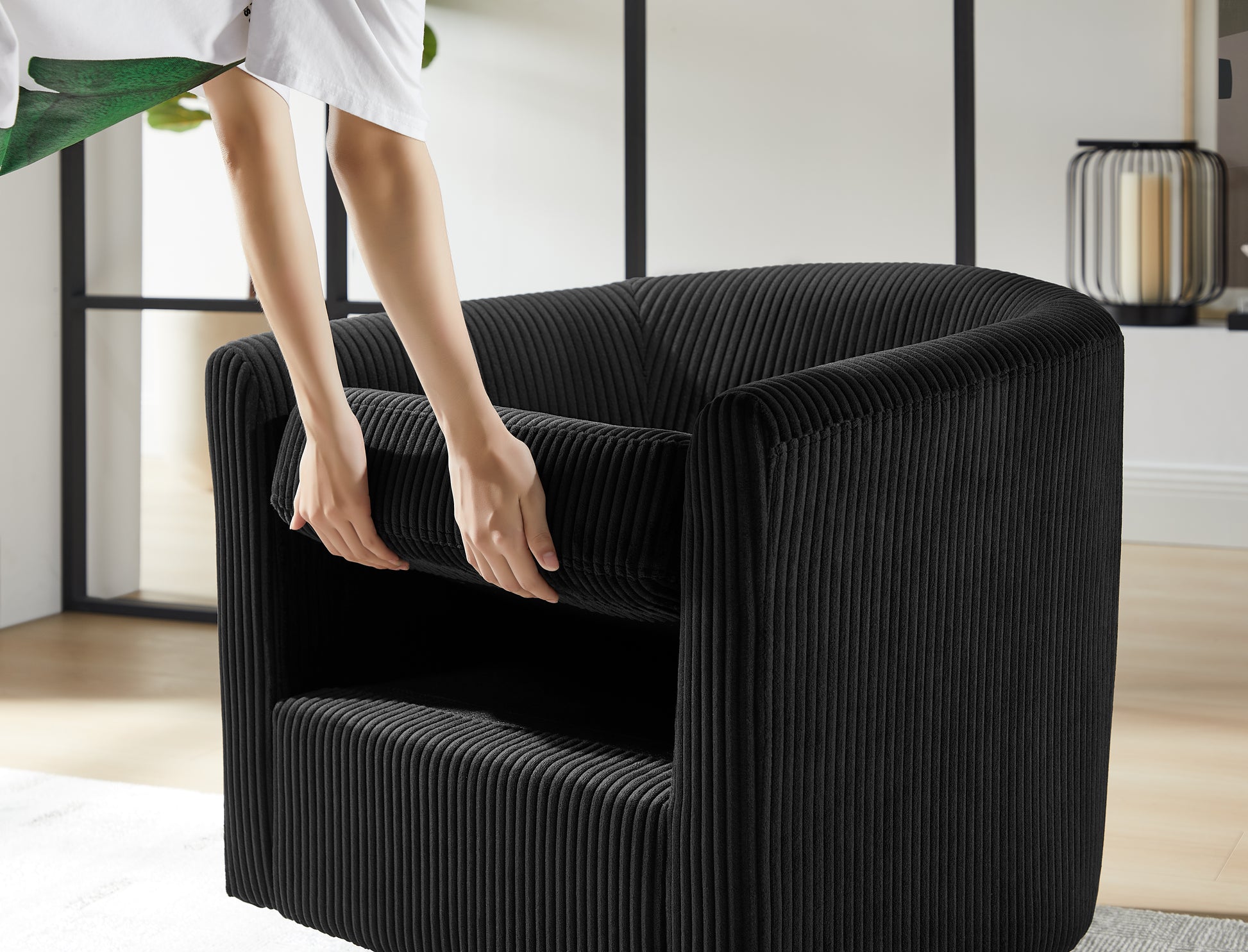 Closeup of a plush black corduroy armchair with removable cushion