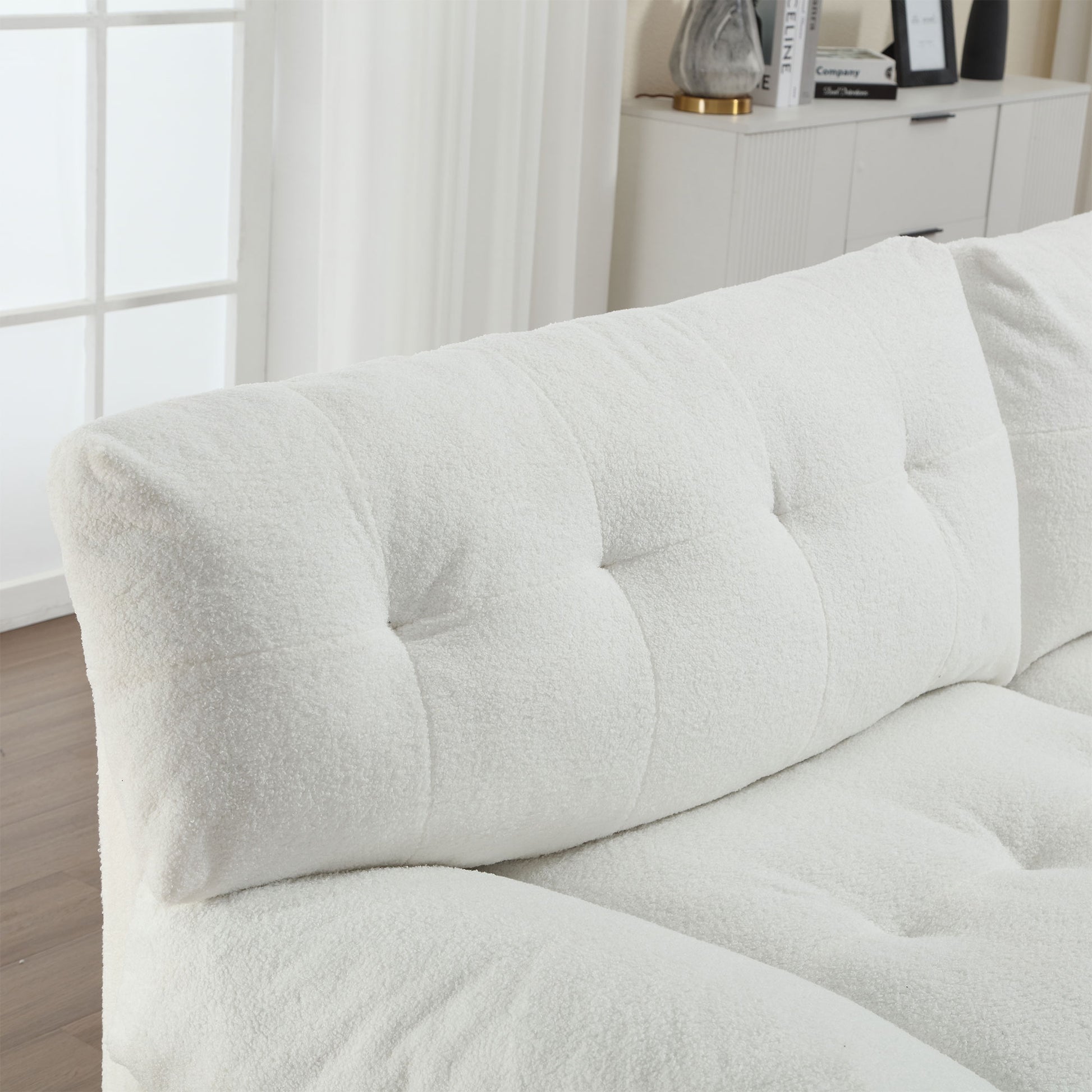 Plush white boucl fabric sofa with tufted back cushions for a cozy living room