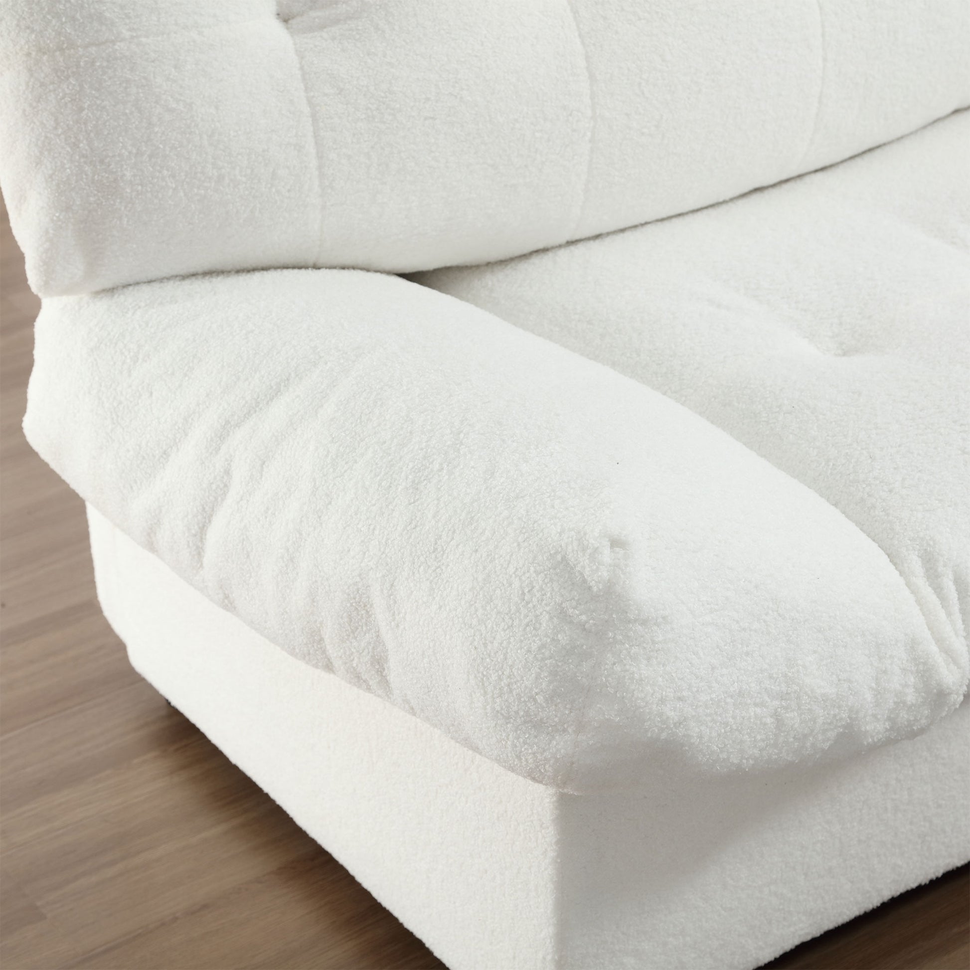 Plush white boucle sofa armrest with tufted seat detail