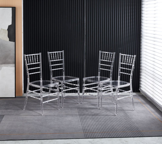 Four clear acrylic ghost chairs with a modern design arranged in a room