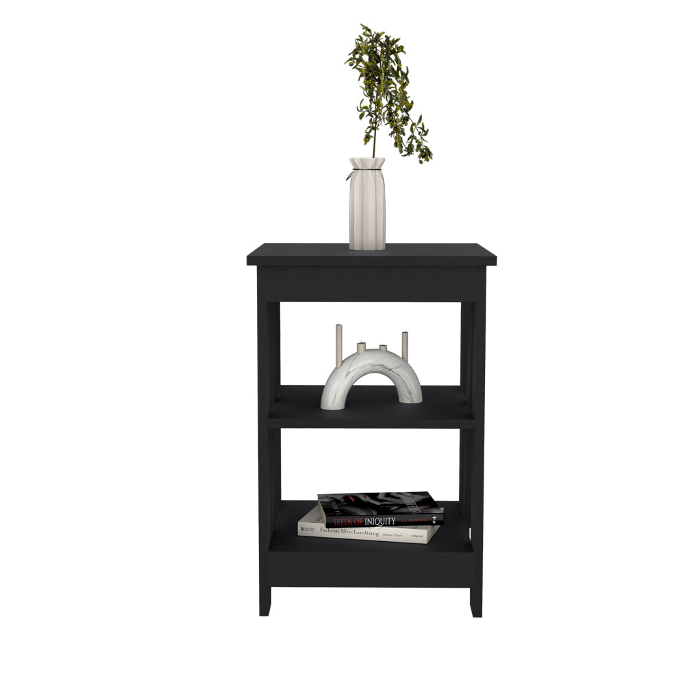 Black wood bedside table with three open shelves a vase with green plant on top shelf and books on bottom shelf