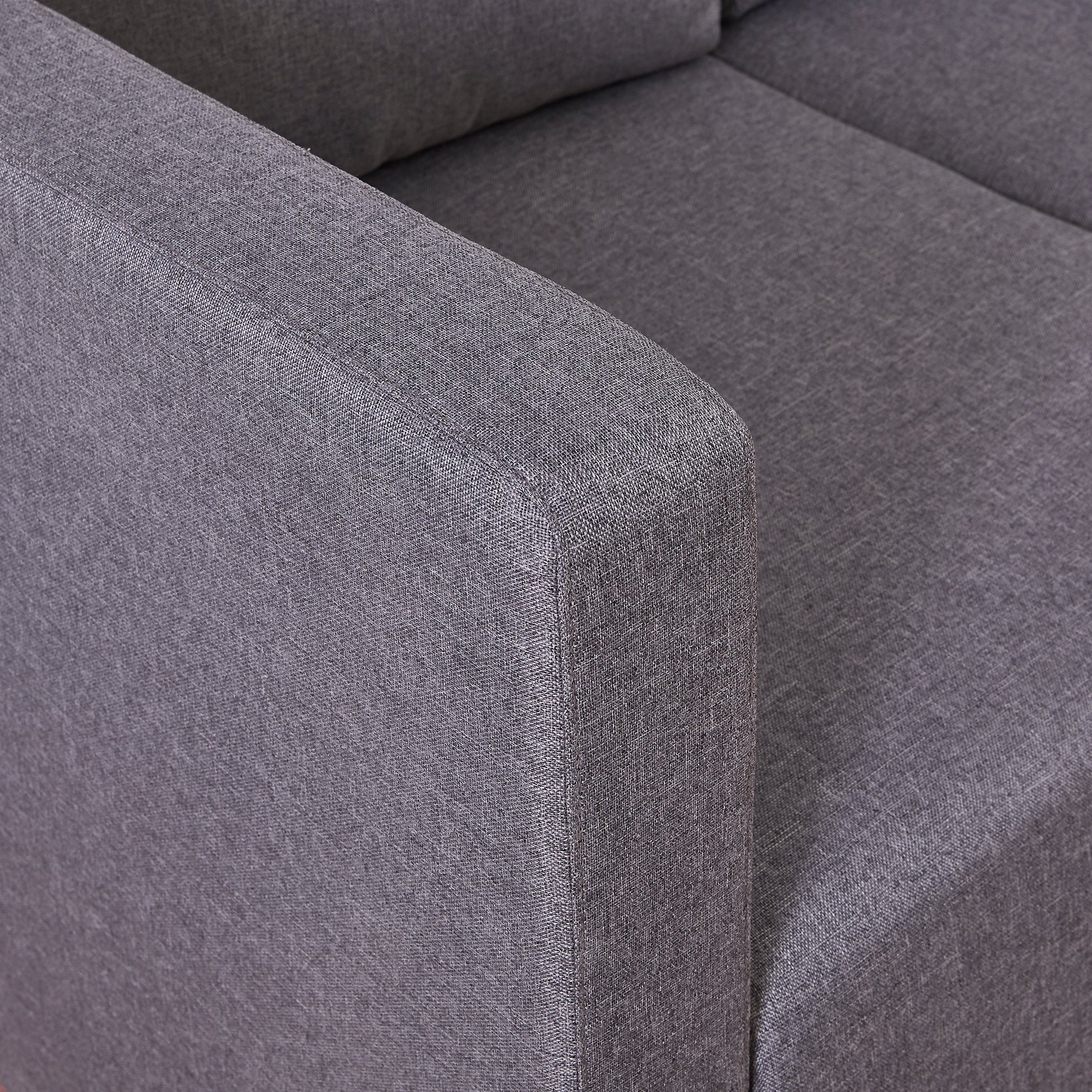 Closeup of a charcoal grey fabric couch armrest showcasing textured woven material