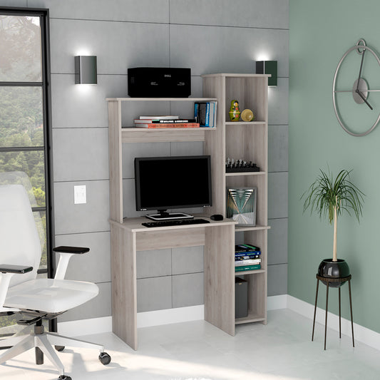 Light oak computer desk with integrated shelving and a black monitor keyboard and mouse