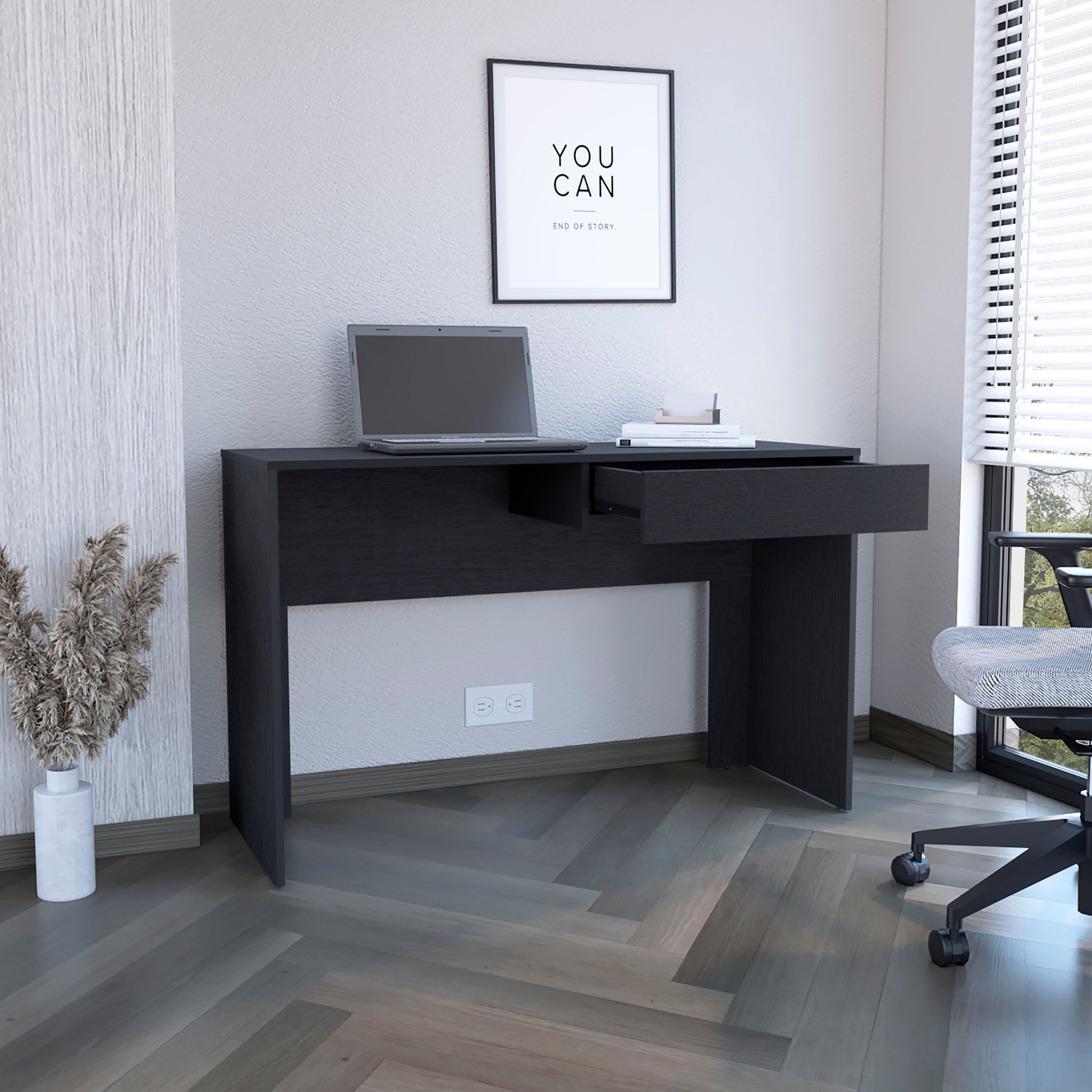 Minimalist dark wood computer desk with an open drawer a laptop and books