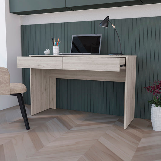 Light wood desk with two drawers a laptop and a black desk lamp