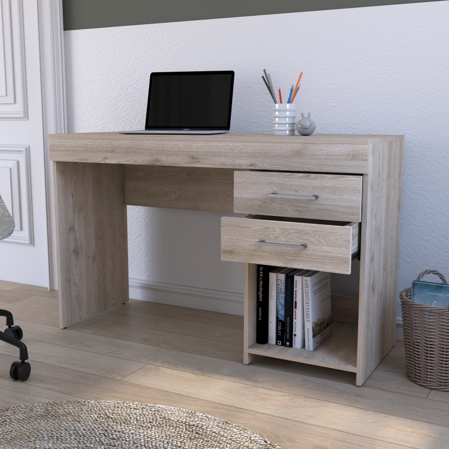 Light oak laminate computer desk with two drawers and an open shelf holding a laptop and books