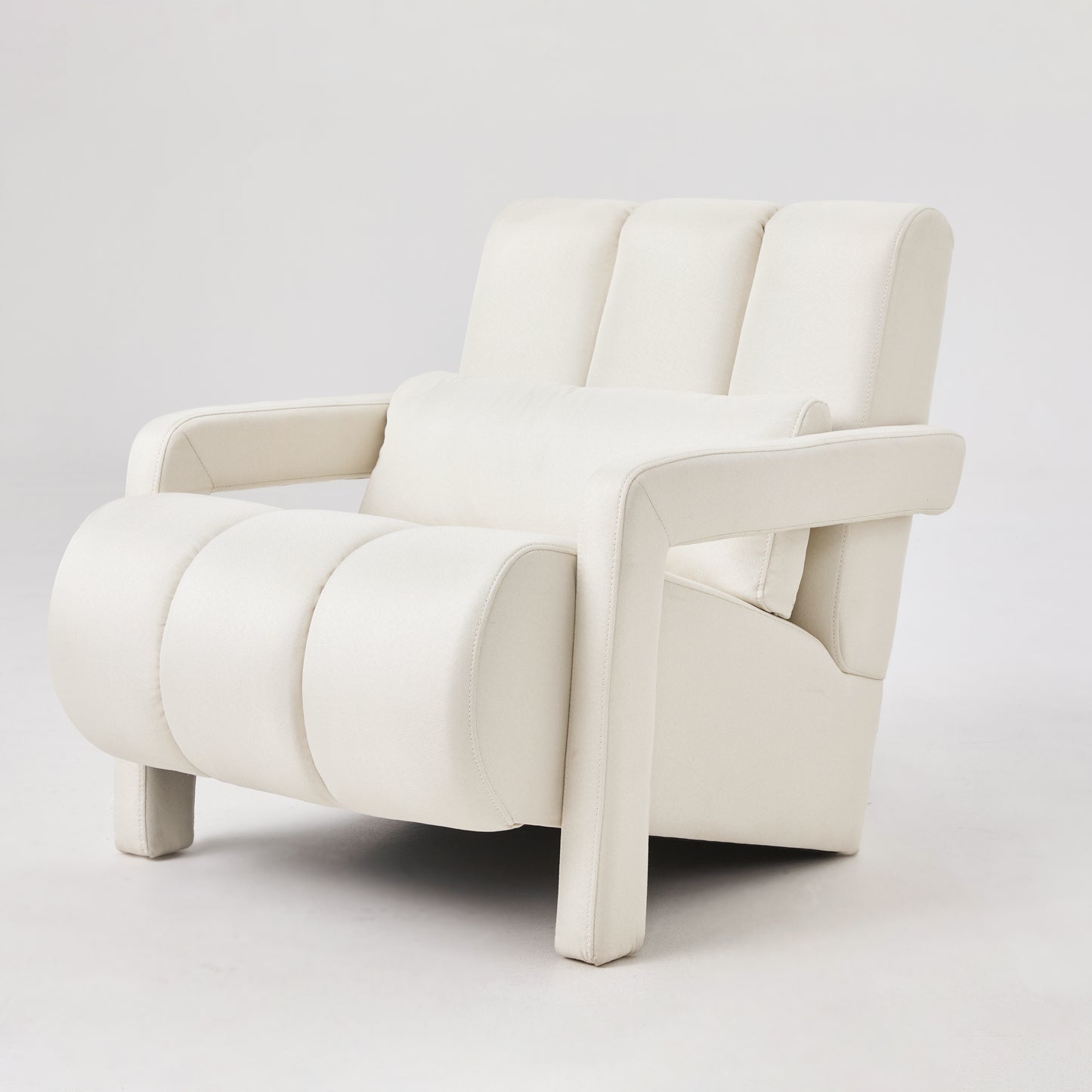Cream textured fabric armchair with plush cushioning and a matching lumbar pillow