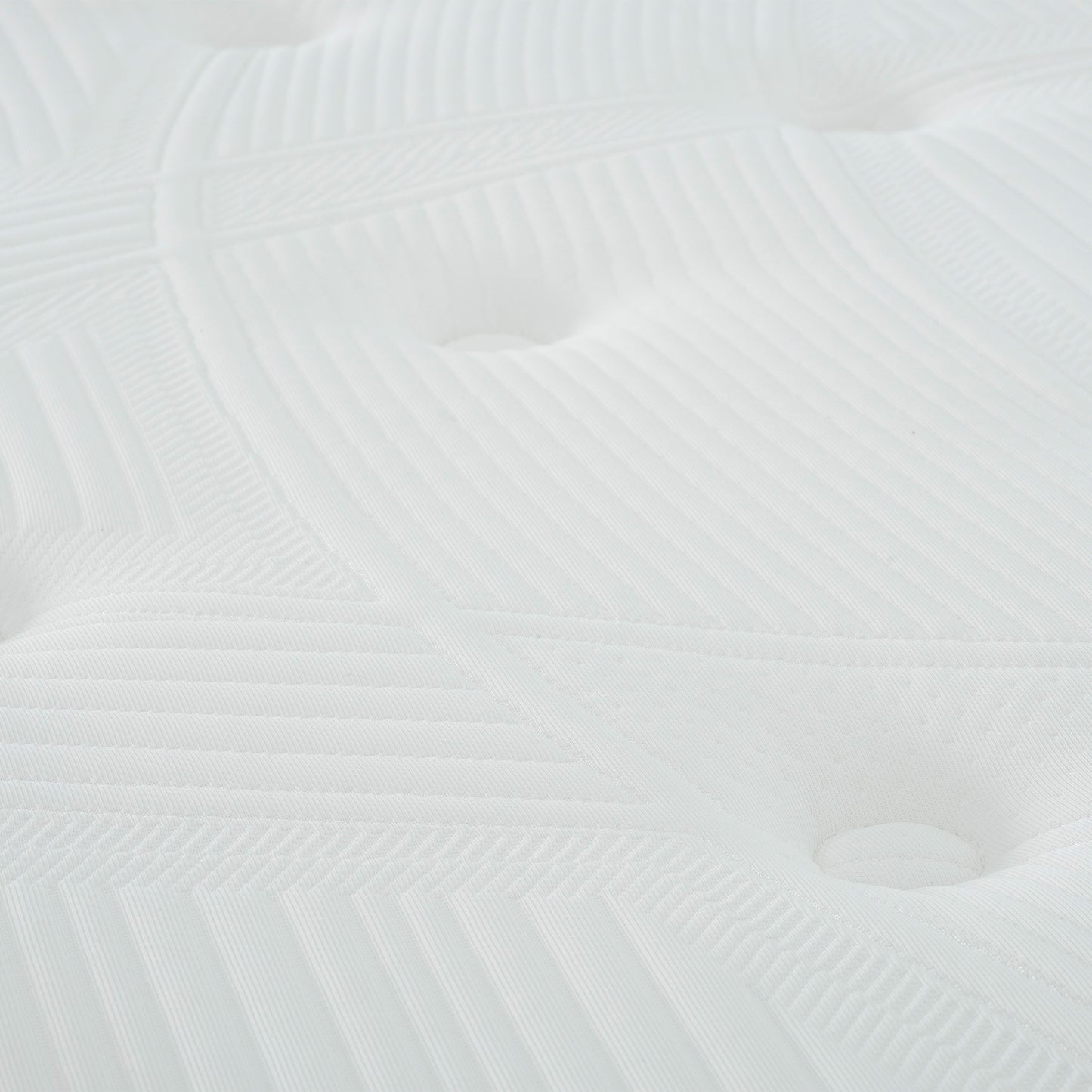 Closeup of a white quilted mattress surface with tufted buttons and geometric stitching details