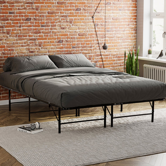 Modern platform bed frame with black metal legs and gray bedding in a loft apartment setting