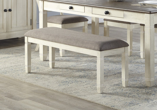 Farmhouse style dining bench with upholstered grey seat and distressed white frame