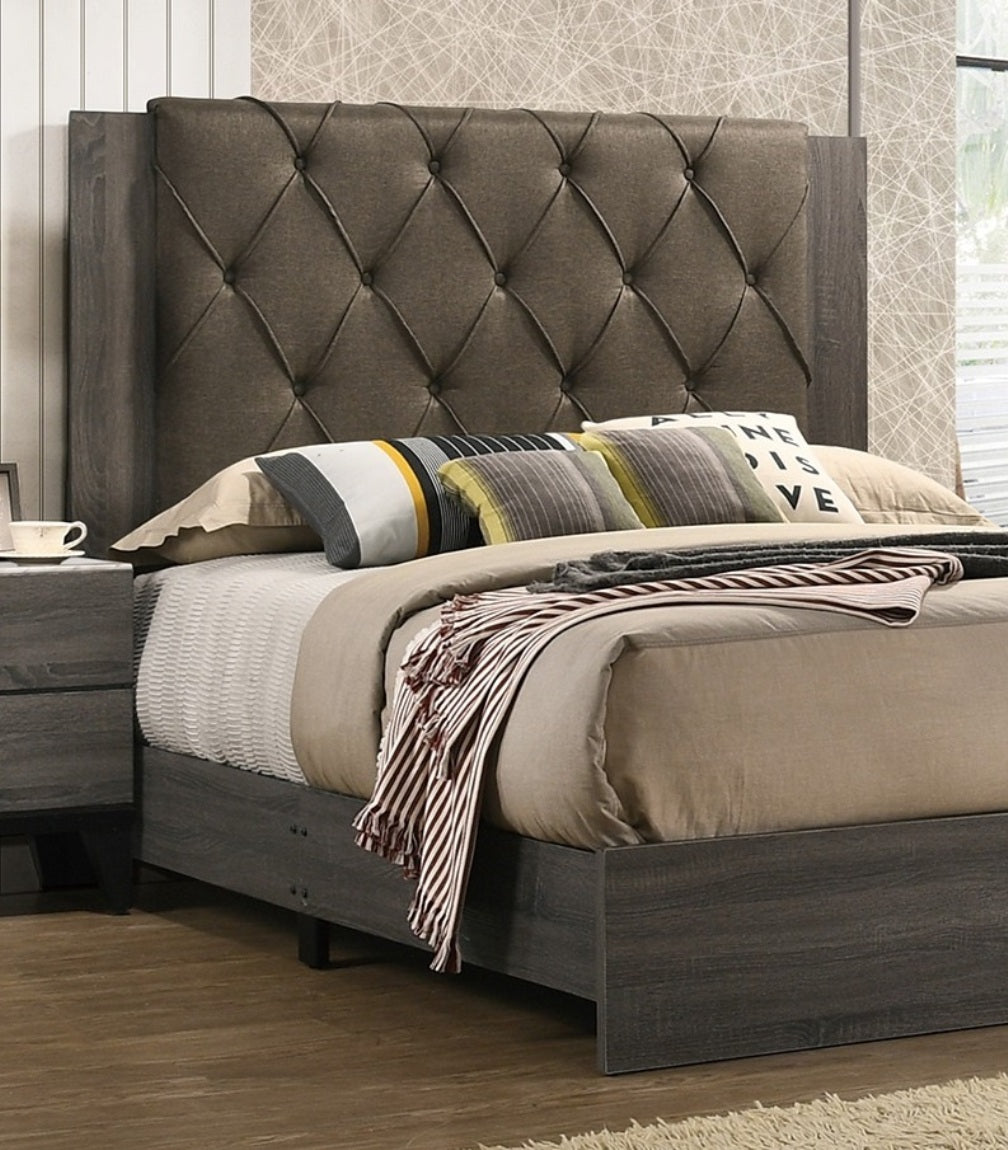 Tufted charcoal grey fabric headboard on a dark wood king bed frame