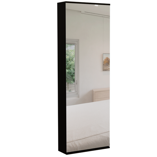 Black framed tall mirror reflecting a bedroom scene with a light wood dresser and window view