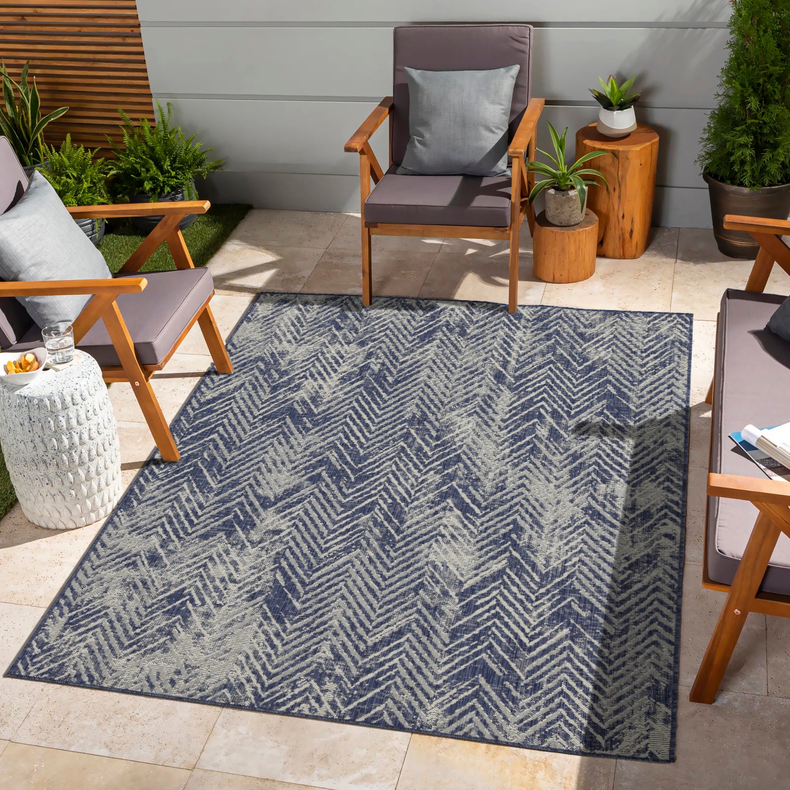 Navy blue outdoor rug with a textured herringbone pattern for patio seating areas