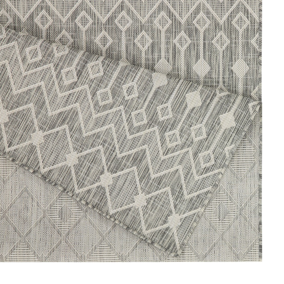 Gray geometric patterned outdoor rug showing diamond and zigzag designs made of durable synthetic fibers