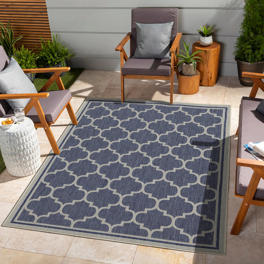 Navy blue outdoor rug with a white quatrefoil pattern and border