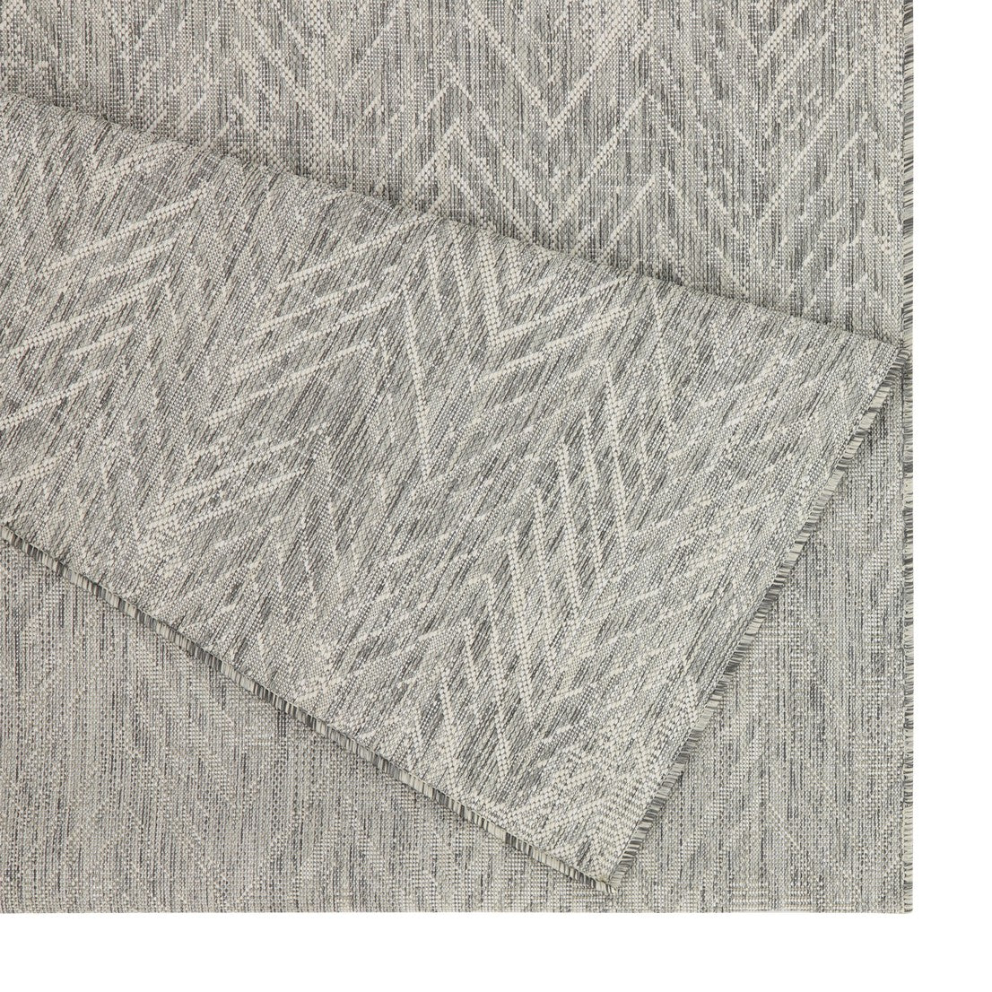 Closeup of a grey chevron pattern outdoor rug with textured weave