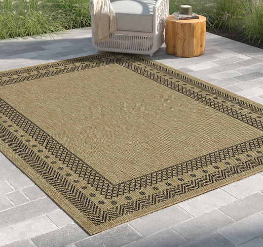 Tawny woven outdoor rug with black geometric border suitable for patios