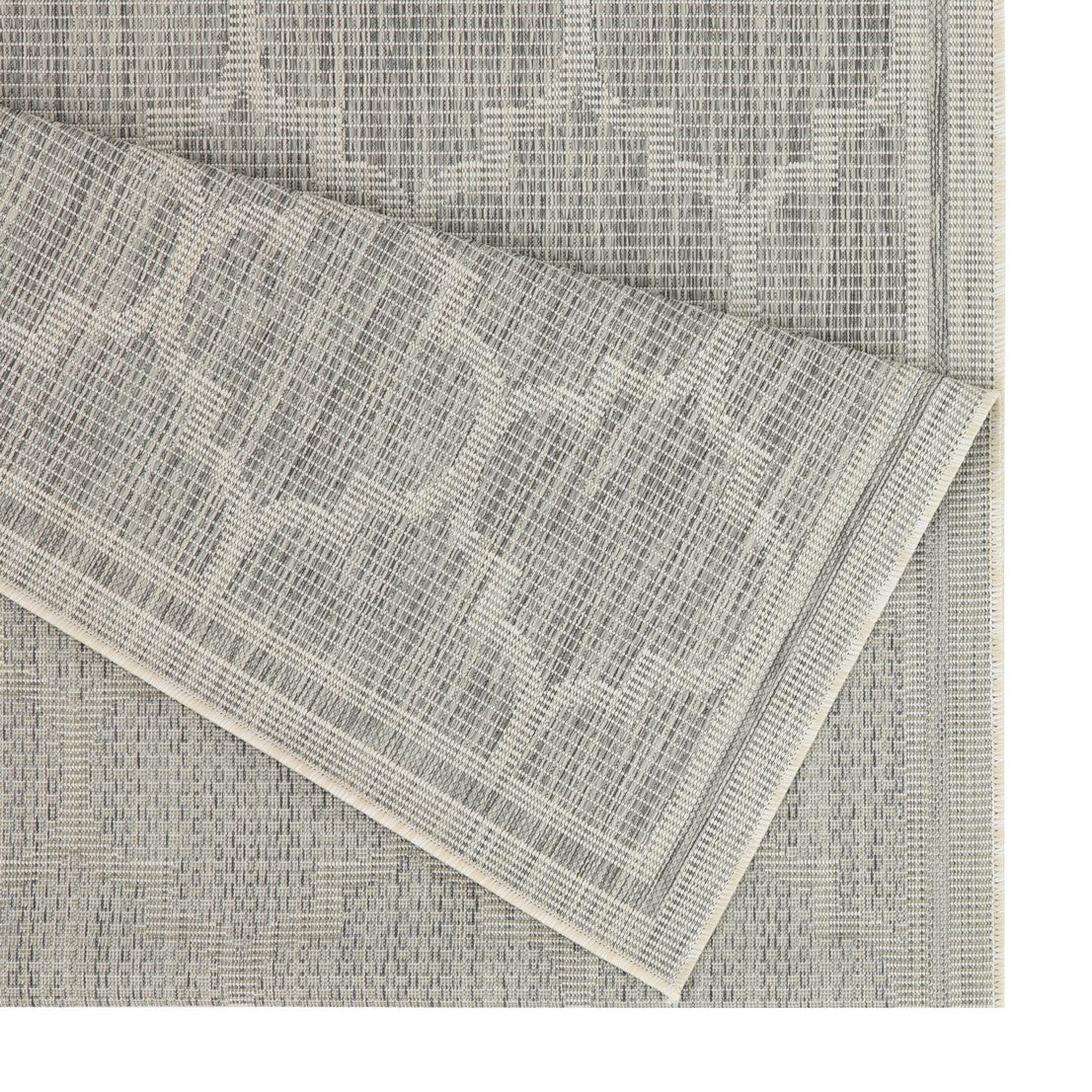 Closeup of a grey textured rug with a subtle geometric pattern showing woven fibers