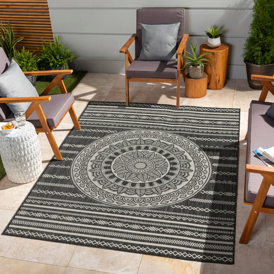 Dark gray outdoor rug with a large cream mandala design and striped borders