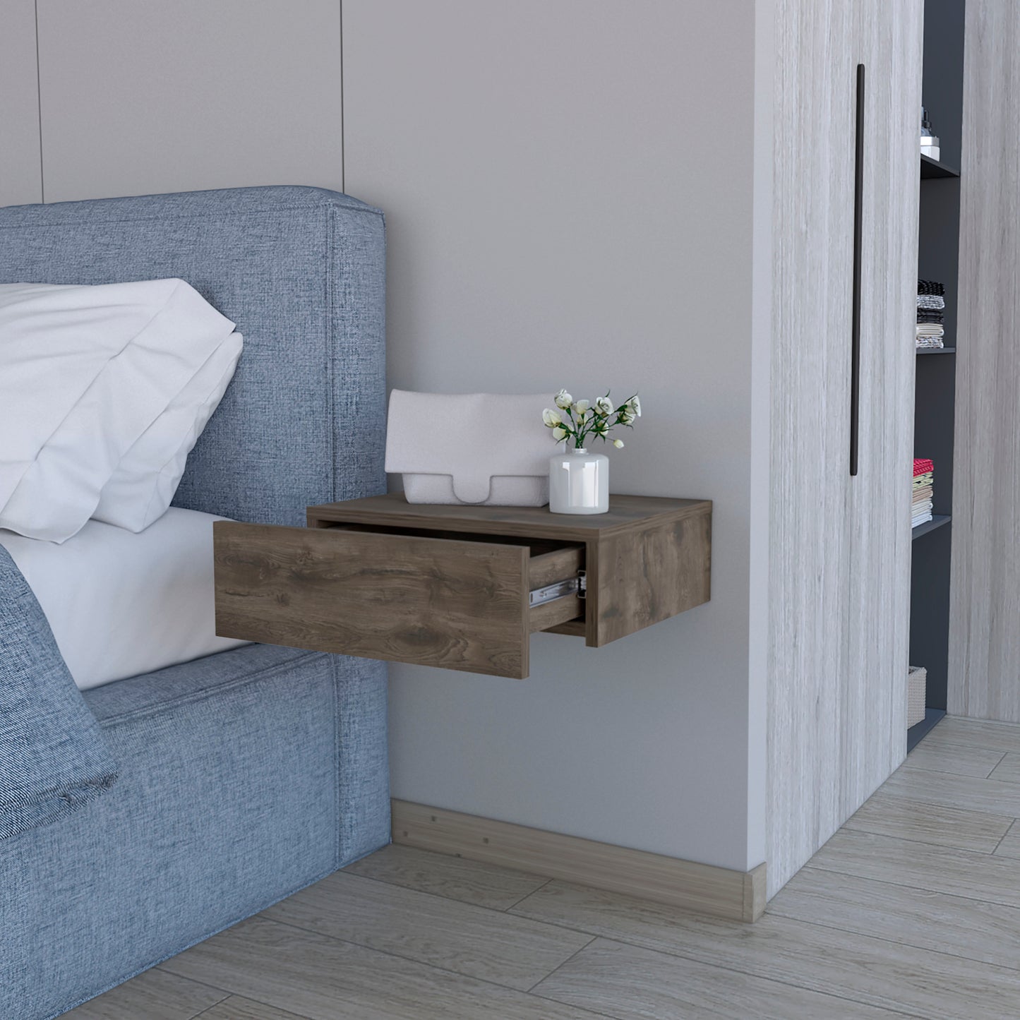 Modern floating nightstand with dark wood finish and open drawer beside a blue upholstered bed
