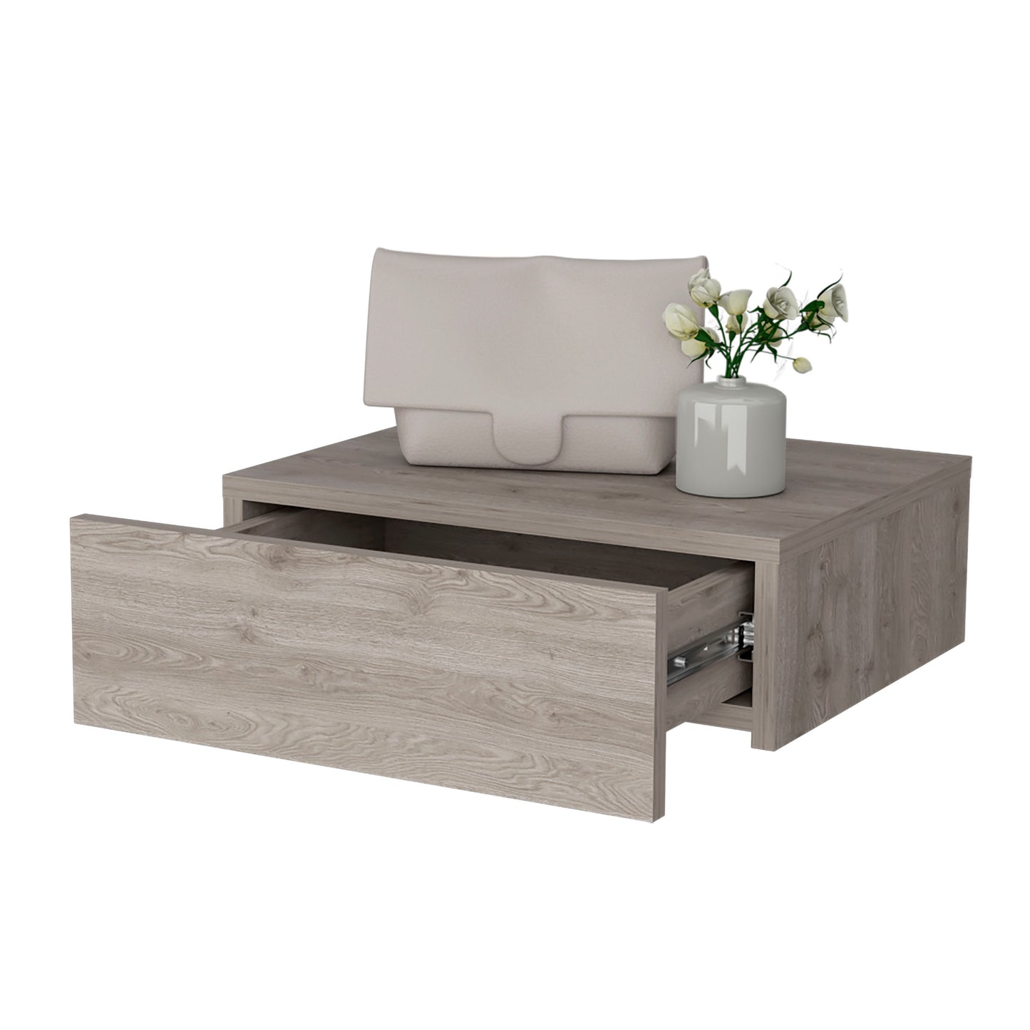 Modern grey wood floating nightstand with open drawer displaying drawer slides a beige clutch bag and a vase of white flowers
