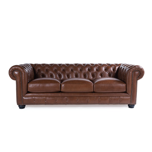 Brown leather chesterfield sofa with button tufting and silver nailhead trim